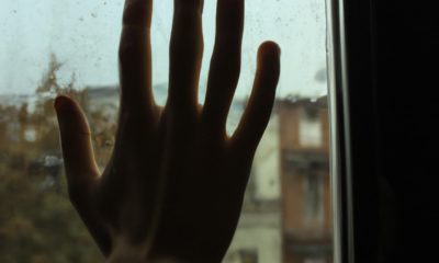 Main sur fenêtre déprime