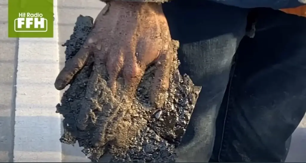 Main collé avec du bitume