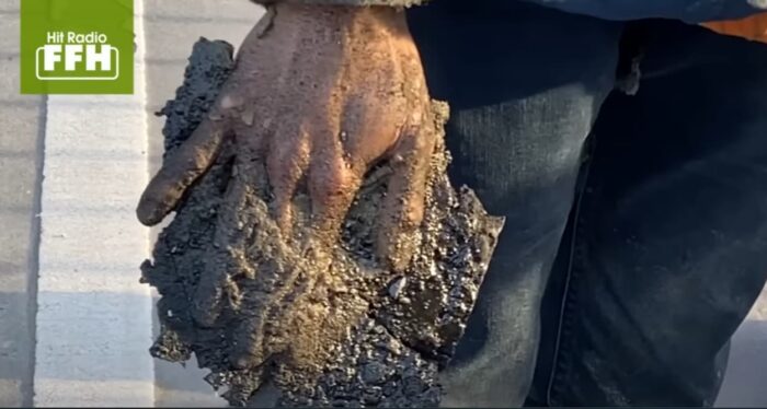 Main collé avec du bitume